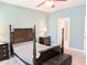 Well-lit bedroom features a four-poster bed, ceiling fan, and soft carpeting at 2472 Patriot Bluffs Dr, Fuquay Varina, NC 27526