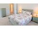 Comfortable bedroom showcases a queen bed with floral pattern, side tables, and a view of the ensuite bathroom at 2472 Patriot Bluffs Dr, Fuquay Varina, NC 27526