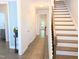 Bright hallway with hardwood floors, staircase, and views to the backyard at 2472 Patriot Bluffs Dr, Fuquay Varina, NC 27526