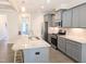 Lovely kitchen with granite counters, stainless appliances, a kitchen island with seating, and gray cabinets at 2472 Patriot Bluffs Dr, Fuquay Varina, NC 27526