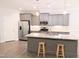 Beautiful kitchen boasts an island with granite countertops, stainless appliances and stylish gray cabinets at 2472 Patriot Bluffs Dr, Fuquay Varina, NC 27526