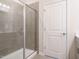 Bathroom featuring a glass door, tile floors and walls, and a door leading to other rooms at 253 Sweet Olive St, Clayton, NC 27527