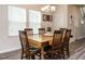 Well-lit dining room featuring a wooden table, six chairs, and modern gray flooring, perfect for Gathering meals at 253 Sweet Olive St, Clayton, NC 27527