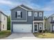 Charming two-story home with gray siding, a white garage door, and a well-manicured front yard at 253 Sweet Olive St, Clayton, NC 27527