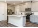 Spacious kitchen with an island, stainless steel appliances, gray cabinets, and a modern design at 253 Sweet Olive St, Clayton, NC 27527