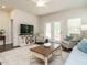 Bright living room featuring a ceiling fan, decor, and access to the outdoor space through glass doors at 253 Sweet Olive St, Clayton, NC 27527