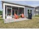 Relaxing screened-in patio with orange Adirondack chairs and a small table, ideal for outdoor enjoyment at 253 Sweet Olive St, Clayton, NC 27527