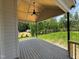 Covered back porch featuring a ceiling fan and views of the private backyard at 27 Batten Hill Ln, Selma, NC 27576