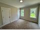Bedroom featuring carpet, a door, and two windows at 27 Batten Hill Ln, Selma, NC 27576