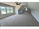 Spacious bonus room with a ceiling fan, multiple windows, and plush carpeting at 27 Batten Hill Ln, Selma, NC 27576