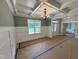 Bright dining room featuring wainscoting, coffered ceilings, and a modern chandelier at 27 Batten Hill Ln, Selma, NC 27576