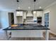 Modern kitchen with white cabinets, mosaic backsplash, and a spacious island with sink at 27 Batten Hill Ln, Selma, NC 27576