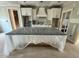 Spacious kitchen with a large center island, modern white cabinets, and a range hood at 27 Batten Hill Ln, Selma, NC 27576