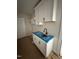 Laundry room with white cabinets, shelving, and black faucet at 27 Batten Hill Ln, Selma, NC 27576