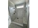 Luxurious walk-in shower featuring marble-style tile, a bench, and a sleek shower head at 27 Batten Hill Ln, Selma, NC 27576