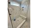 Modern walk-in shower with marble-like tile, a built-in bench, and a rainfall shower head at 27 Batten Hill Ln, Selma, NC 27576