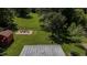 Aerial view of a lush backyard, showcasing a stone patio with outdoor seating and well-maintained greenery at 2715 Freemont Rd, Durham, NC 27705