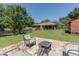 Expansive backyard featuring a stone patio with a fire pit and well-manicured lawn at 2715 Freemont Rd, Durham, NC 27705