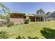 Large backyard with lush grass, mature trees, and a covered patio area for outdoor entertaining at 2715 Freemont Rd, Durham, NC 27705
