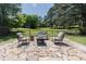 Spacious stone patio with comfortable seating around a fire pit, perfect for outdoor gatherings at 2715 Freemont Rd, Durham, NC 27705