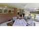 Inviting covered patio with outdoor dining area, ceiling fan, brick wall, and comfortable seating at 2715 Freemont Rd, Durham, NC 27705