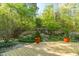 Lush backyard with a well-manicured garden, wooden deck, and shaded pergola at 2925 Ericka Dr, Hillsborough, NC 27278