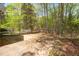 Concrete pad in wooded backyard, providing space for parking or recreation near trees and foliage at 2925 Ericka Dr, Hillsborough, NC 27278
