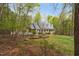 A home surrounded by mature trees with a well-manicured front yard, classic brick accents, and a full front porch at 2925 Ericka Dr, Hillsborough, NC 27278