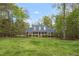 Traditional home with a blue roof, brick accents, white porch, and large front yard surrounded by mature trees at 2925 Ericka Dr, Hillsborough, NC 27278