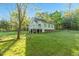 Charming cottage home featuring a deck, situated on a spacious, verdant lawn surrounded by mature trees at 2925 Ericka Dr, Hillsborough, NC 27278