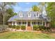 Charming one-story home featuring a welcoming front porch, dormer windows, brick stairs, and mature landscaping at 2925 Ericka Dr, Hillsborough, NC 27278