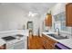 Vaulted kitchen with wood cabinets, white counter tops, stainless steel sink, and white range at 2925 Ericka Dr, Hillsborough, NC 27278