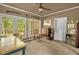 Bright room with many windows, tile floors, ceiling fan and a wooden desk and chair at 2925 Ericka Dr, Hillsborough, NC 27278