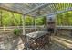 Backyard patio area with stone fireplace, a dining table, and a built-in grill under pergola at 2925 Ericka Dr, Hillsborough, NC 27278