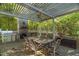 Outdoor dining area under pergola with a stone fireplace and grill at 2925 Ericka Dr, Hillsborough, NC 27278