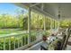 Covered porch showcasing views of the surrounding greenery, with rocking chairs, a ceiling fan, and a decorative rug at 2925 Ericka Dr, Hillsborough, NC 27278