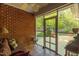 Cozy screened porch with red brick wall and comfortable furniture, perfect for relaxation at 2925 Ericka Dr, Hillsborough, NC 27278