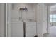 A tidy laundry room with a side-by-side washer and dryer and a wire shelf for storage at 3114 Courtney Creek Blvd, Durham, NC 27713