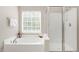Bathroom featuring soaking tub, separate shower, and natural light through window at 3302 Colorcott St, Raleigh, NC 27614