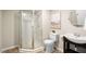 A well lit bathroom shows a stand up shower, a toilet, and a single sink with updated fixtures at 3302 Colorcott St, Raleigh, NC 27614