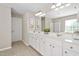 Bathroom with double vanity, white cabinetry, large mirror, and tile flooring at 3302 Colorcott St, Raleigh, NC 27614