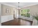 Bright dining room featuring a large window, elegant wainscoting, and modern chandelier at 3302 Colorcott St, Raleigh, NC 27614