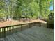 Wooden deck offers a view of the green backyard and mature trees at 3316 Belspring Ln, Raleigh, NC 27612