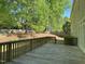 Wooden deck provides views of the manicured lawn, trees, and the surrounding peaceful backyard at 3316 Belspring Ln, Raleigh, NC 27612