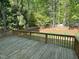Expansive deck overlooking the serene backyard with lush trees and a fenced boundary at 3316 Belspring Ln, Raleigh, NC 27612