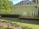 Back exterior of the house features a large wooden deck, a well-kept lawn, and mature landscaping at 3316 Belspring Ln, Raleigh, NC 27612