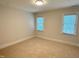 Cozy bedroom with neutral color, plush carpeting, and two windows allowing ample natural light at 3316 Belspring Ln, Raleigh, NC 27612