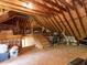 Unfinished attic space showcasing exposed beams, plywood subfloor, and a work station at 3332 Langston Cir, Apex, NC 27539
