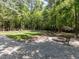 A beautiful backyard with a firepit and lounge chairs surrounded by mature trees at 3332 Langston Cir, Apex, NC 27539