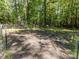 Large backyard with a planting area surrounded by a wooded area and a wire fence at 3332 Langston Cir, Apex, NC 27539